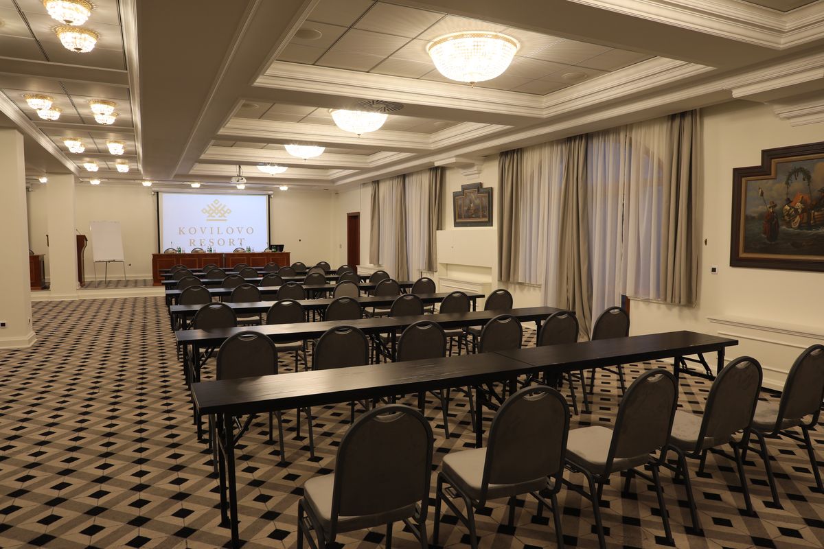 Conference room set classroom-style with projector screen and flipchart.