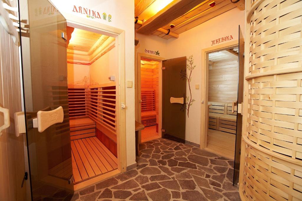 Sauna area with infrared cabin and wood-lined rooms along a stone-floor corridor.