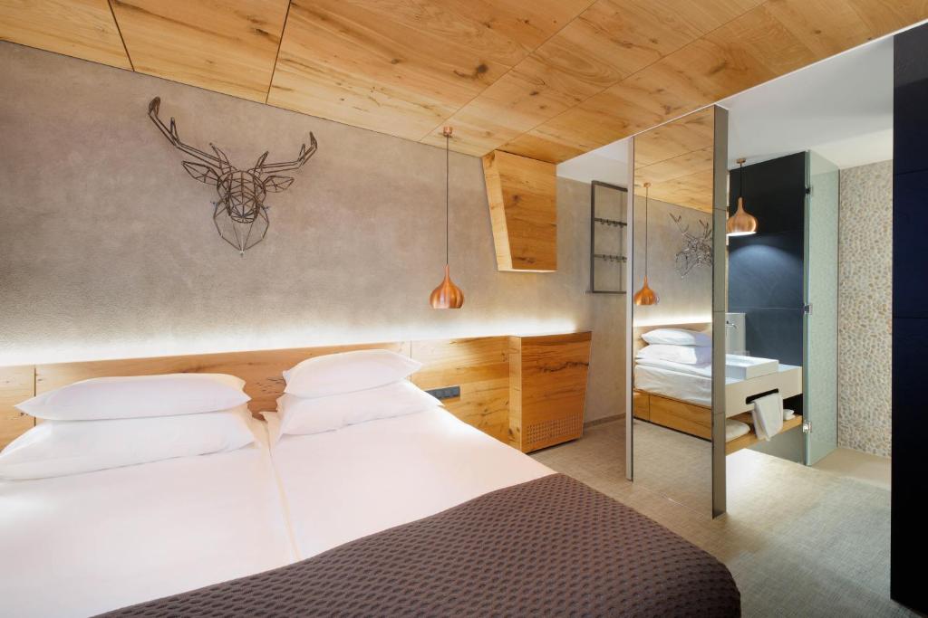 Modern twin room with wooden accents, two beds, and open washbasin area.