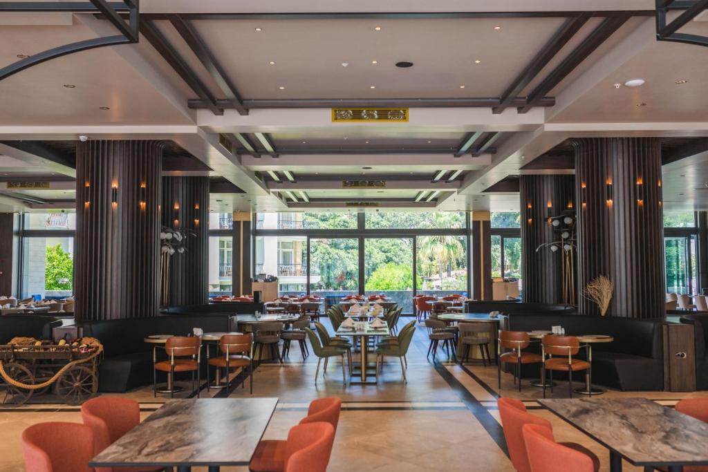 Spacious modern restaurant with large windows, central communal tables, and mixed seating areas.