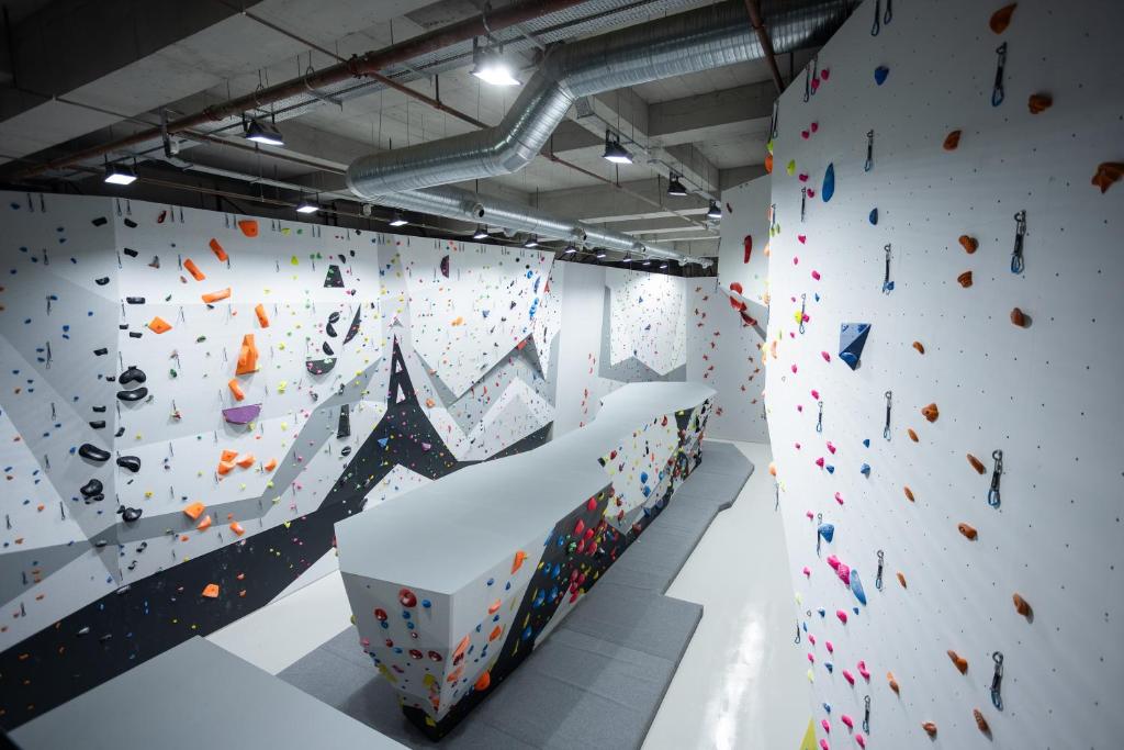 Indoor-Boulderwand mit farbigen Griffen und Sturzmatten für Training-Camp-Einheiten.