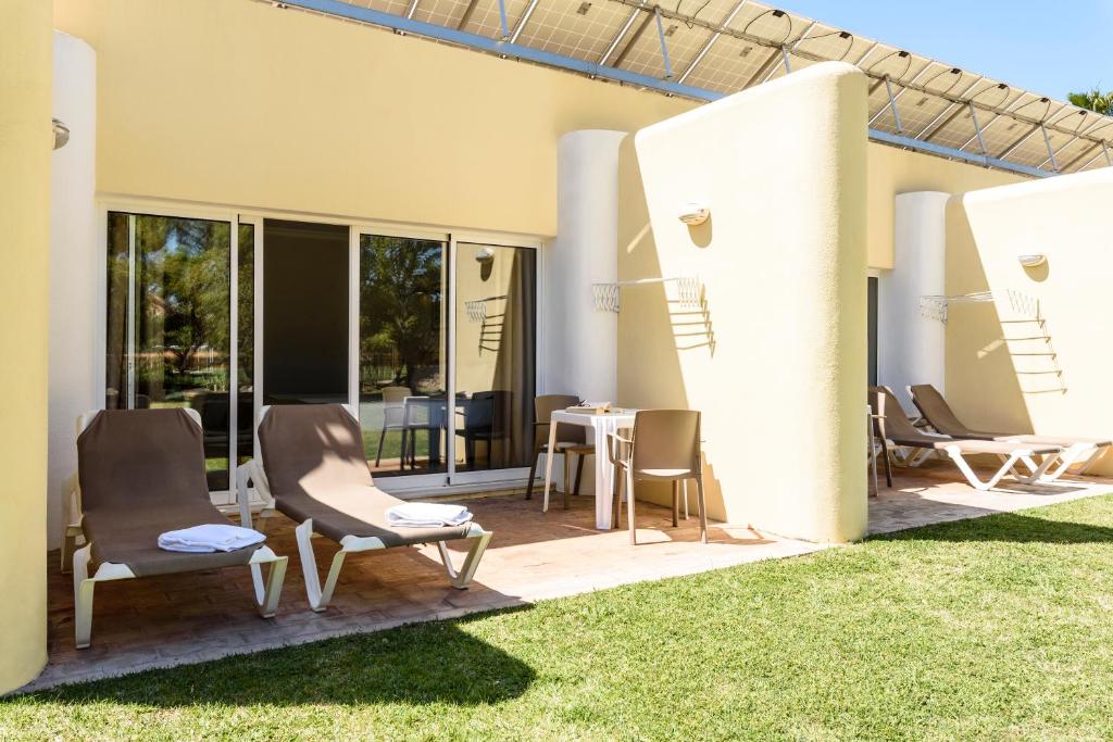Private terrace with sun loungers and outdoor table outside guest rooms.