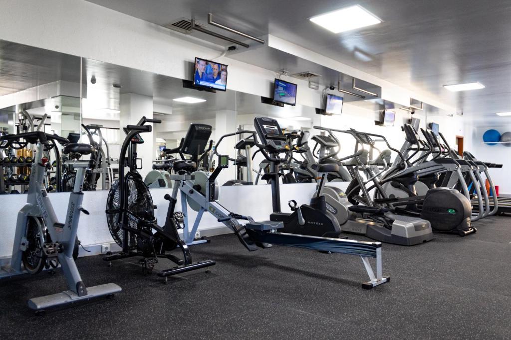 Fitness room with cardio machines, rowing erg and mirrored wall.