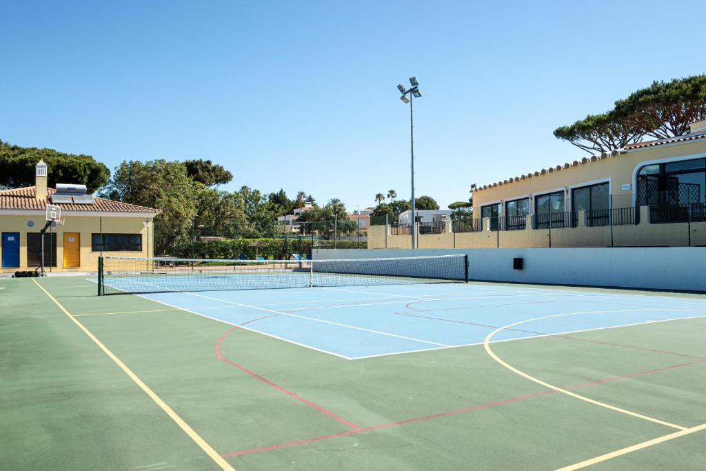 Outdoor multi-sport hard court with net and basketball hoop.