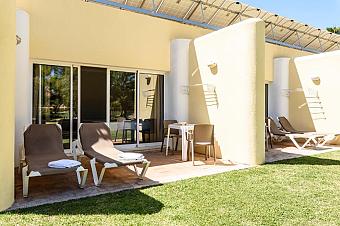 Private terrace with sun loungers and outdoor table outside guest rooms.