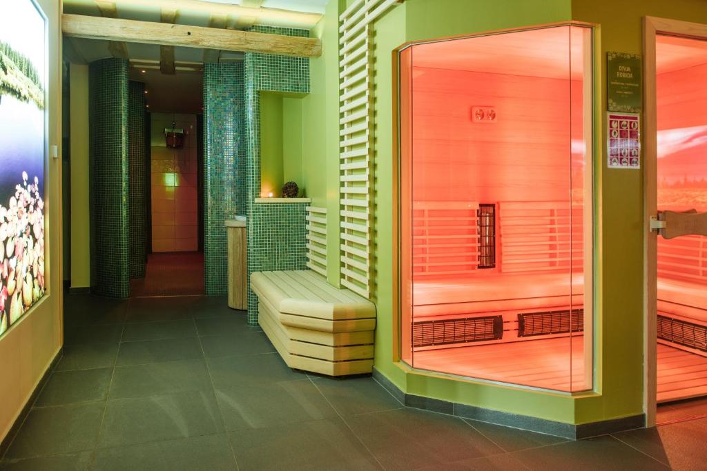 Sauna and wellness corridor with benches, mosaic walls and soft lighting.