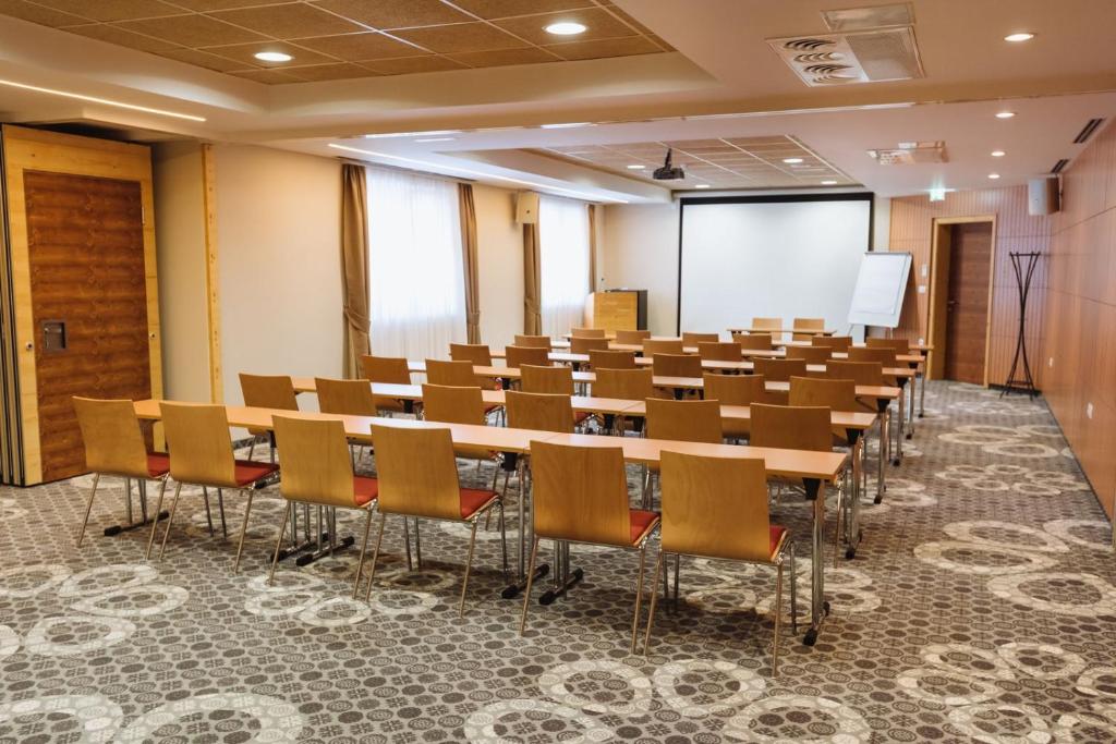 Conference room with classroom seating, screen and flip chart.