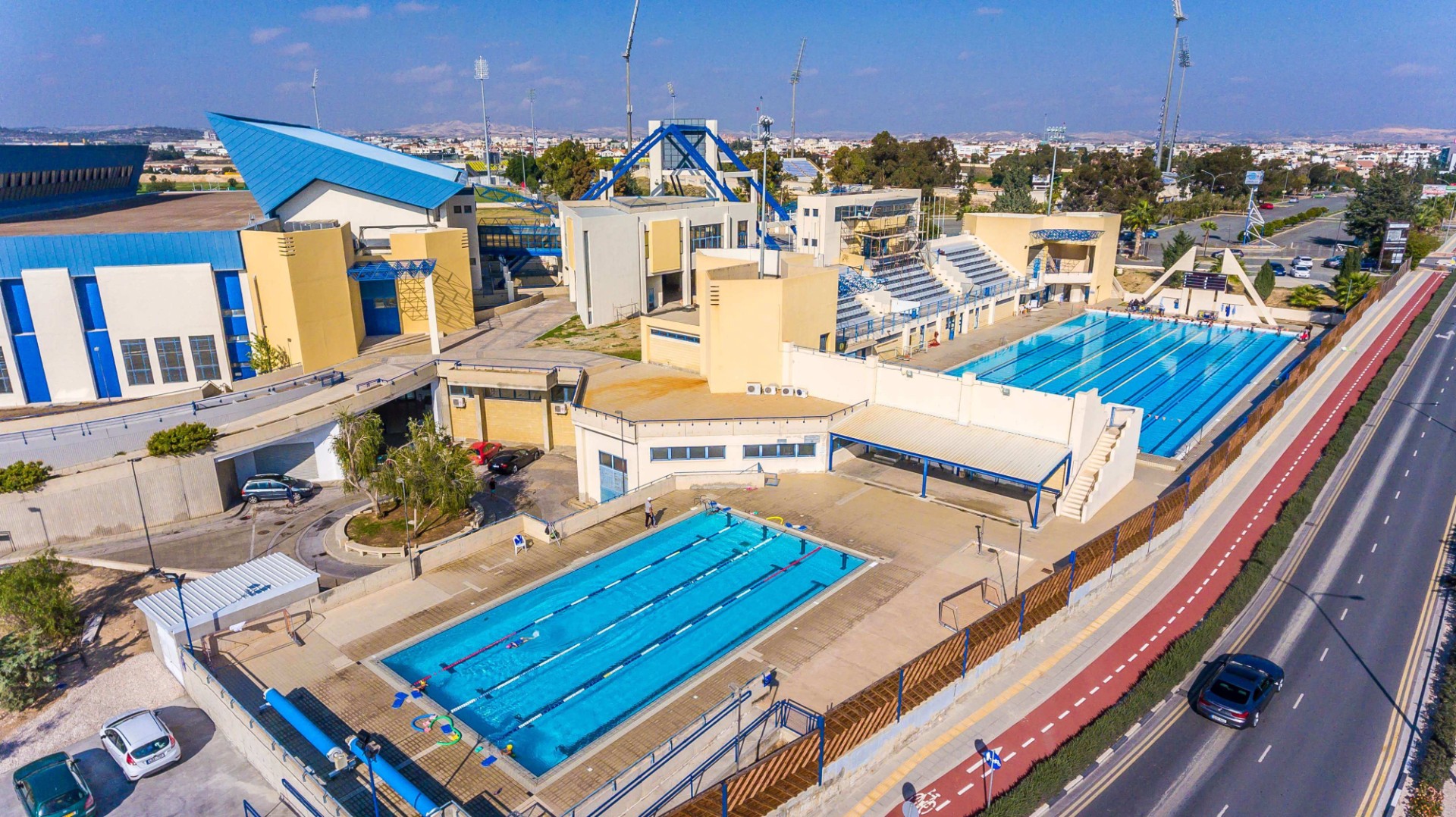 Luftaufnahme von Becken, Tribüne und angrenzenden Sportgebäuden.