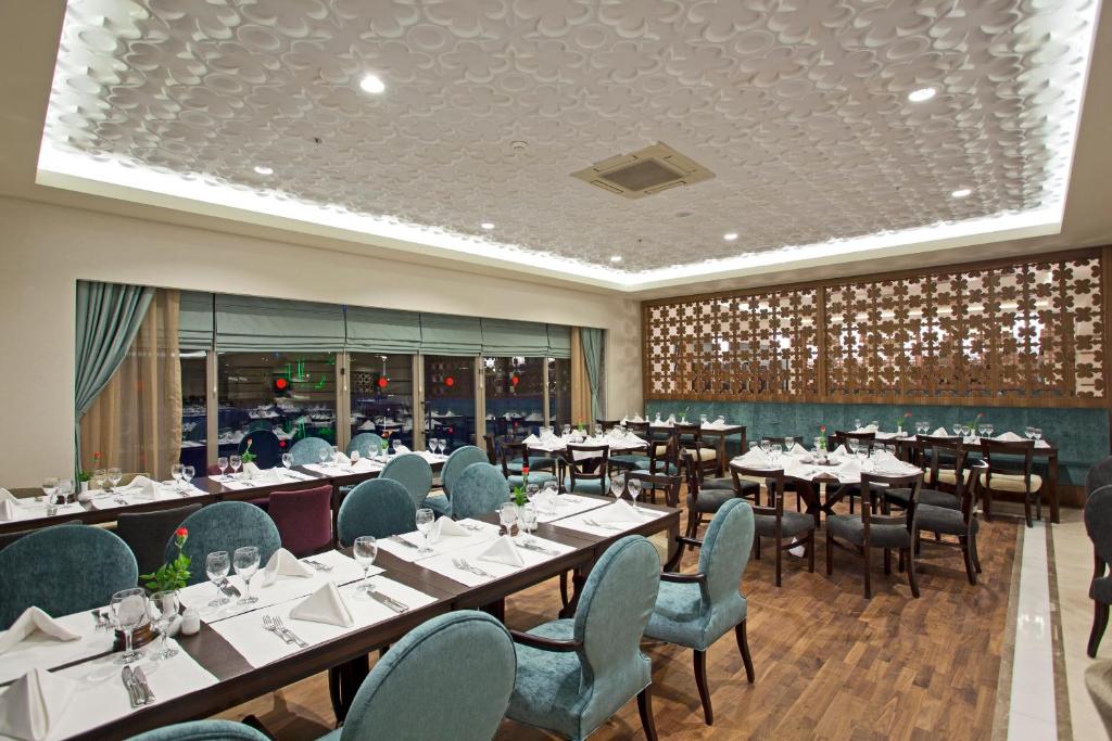 Innenrestaurant mit gedeckten Tischen und gepolsterten Stühlen.