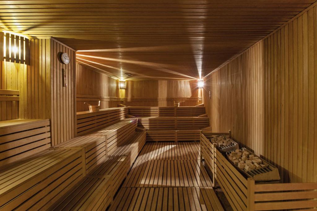Holzverkleidete Sauna mit gestuften Bänken und Ofensteinen.