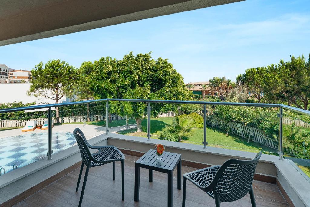Sitzbereich auf dem Balkon mit Blick auf Garten und Poolumgebung.