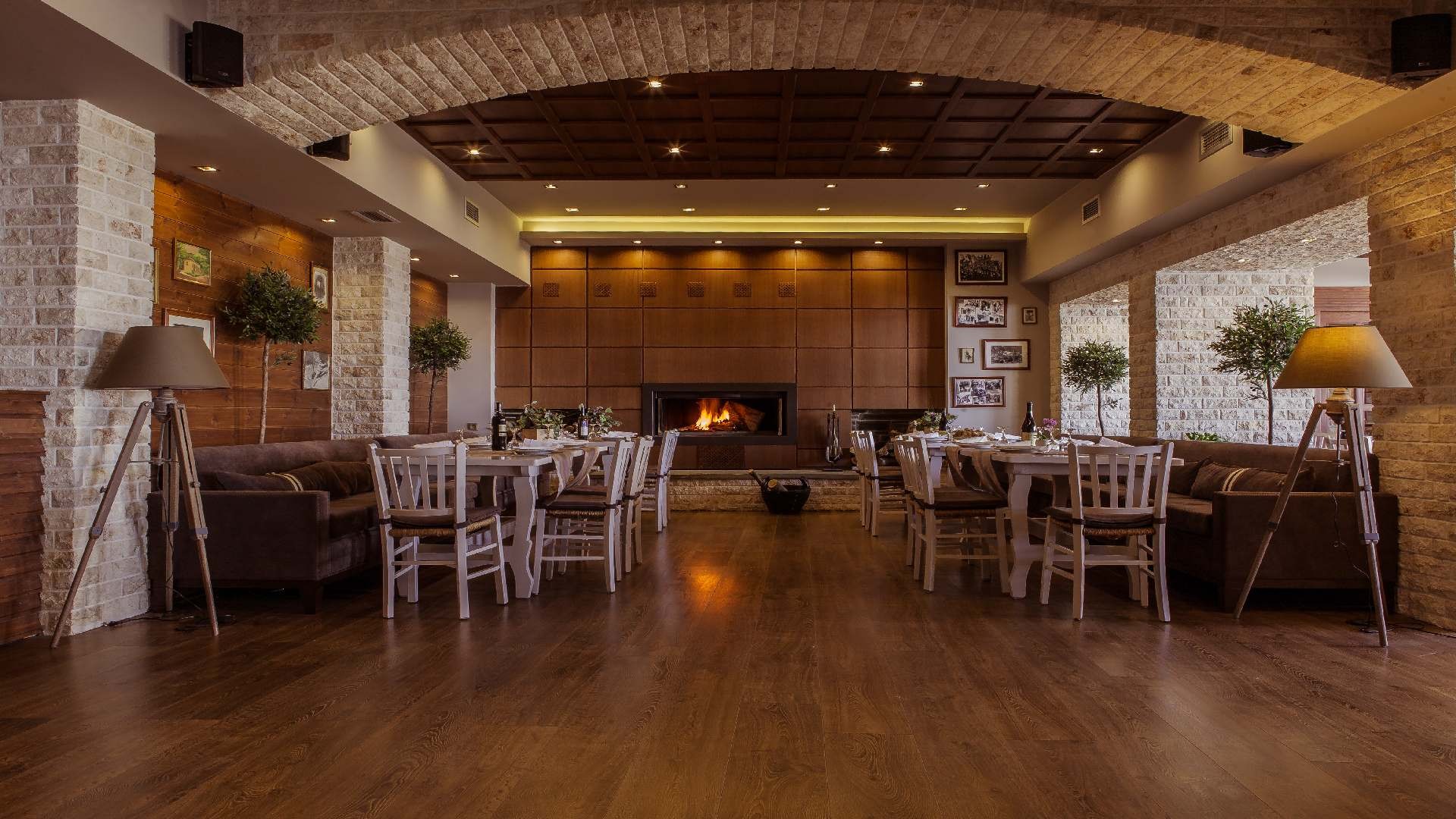 Restaurant dining room with fireplace, wooden floors and lounge seating.