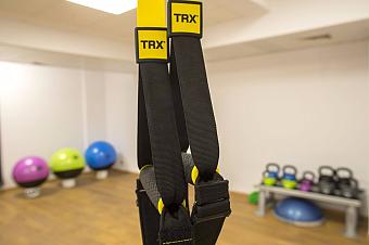 TRX suspension straps in fitness room with exercise balls and kettlebells
