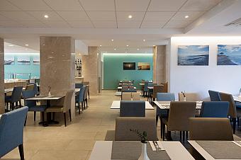 Modern restaurant with blue and beige chairs and light-colored decor