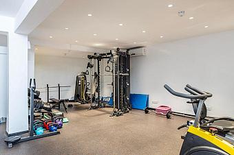 Well-equipped fitness room with treadmills, strength machines, and free weights for athlete training