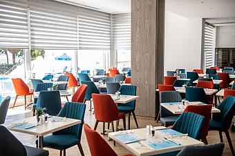 Modern indoor dining area with colorful blue and orange chairs arranged around square tables