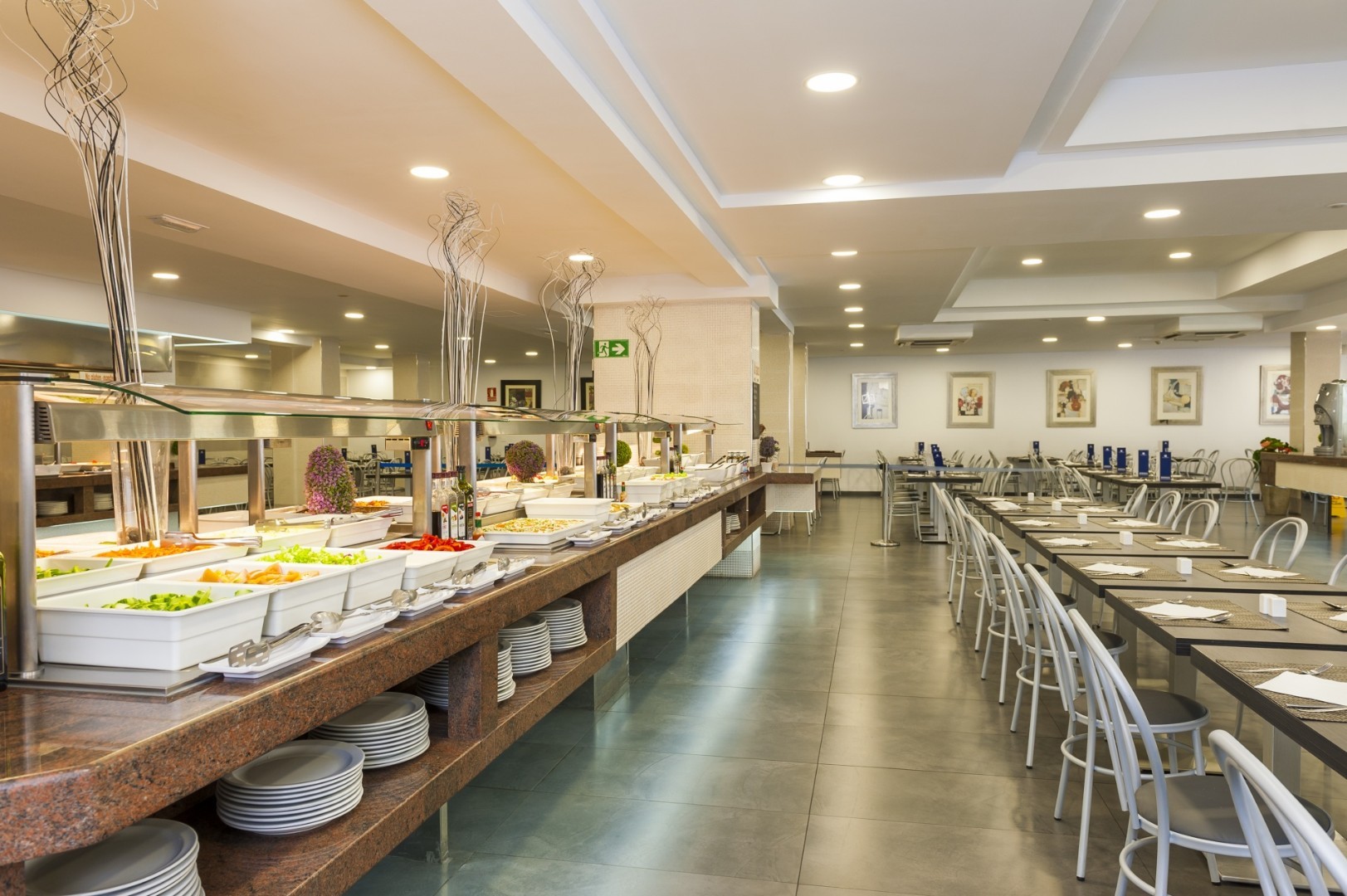Self-service buffet restaurant with a long serving counter and dining tables.