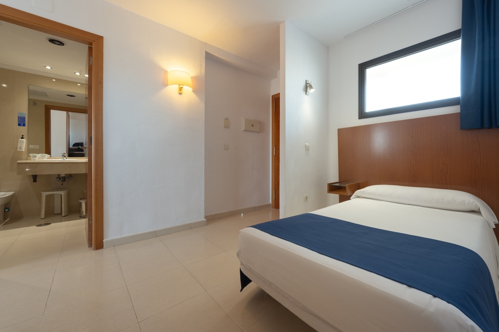 Single room with bathroom entrance and bedside table.