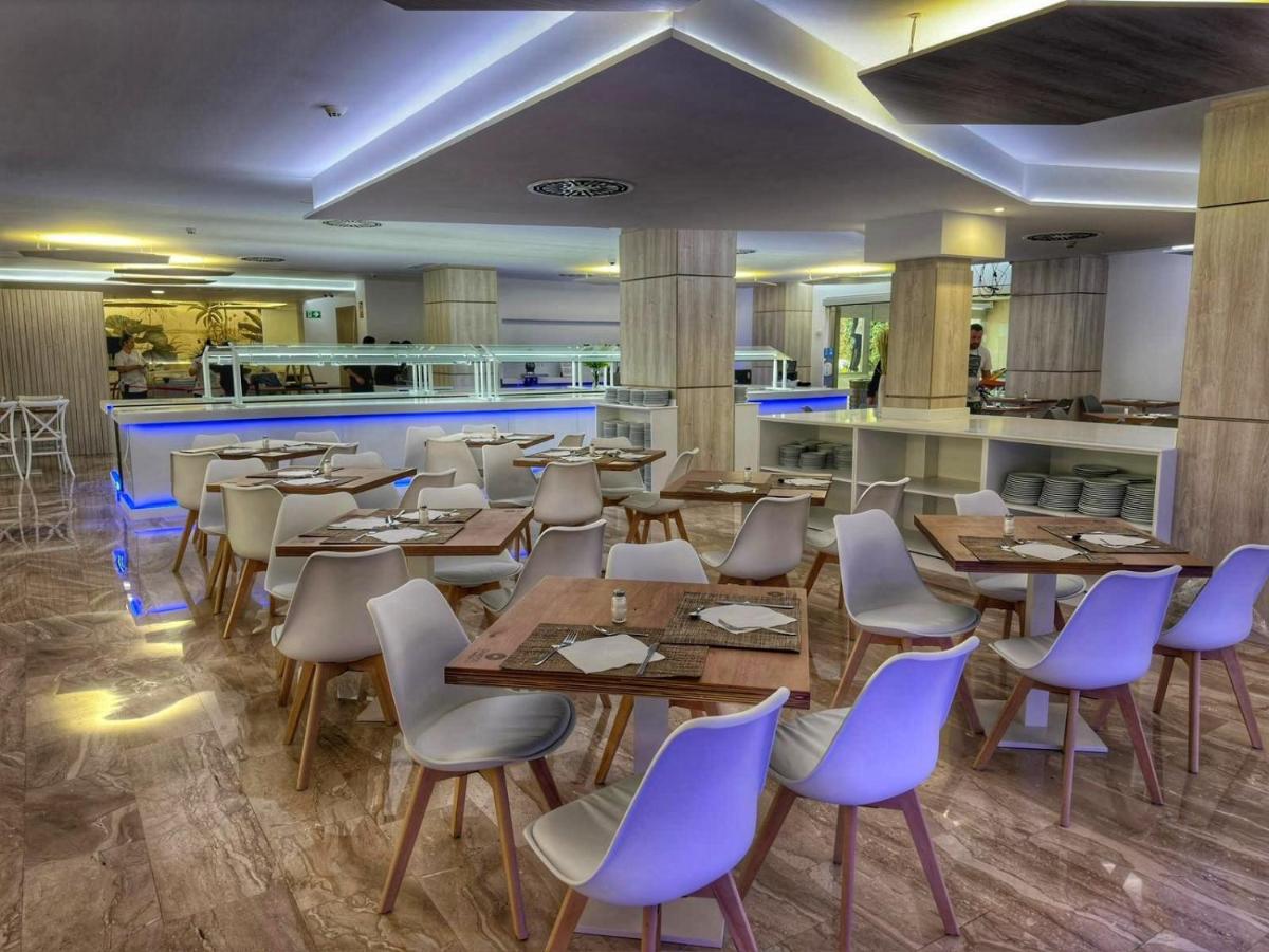 Buffet restaurant dining room with set tables and a self-service counter.