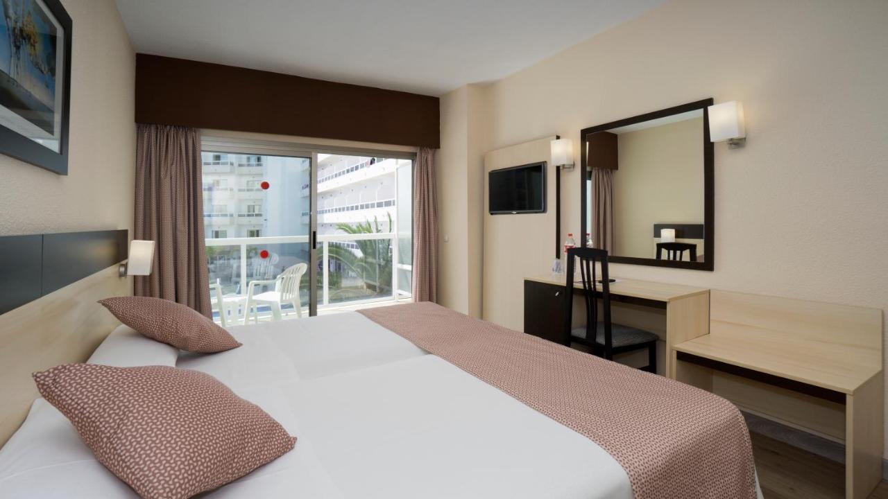 Twin room with balcony, TV, desk, and wall mirror
