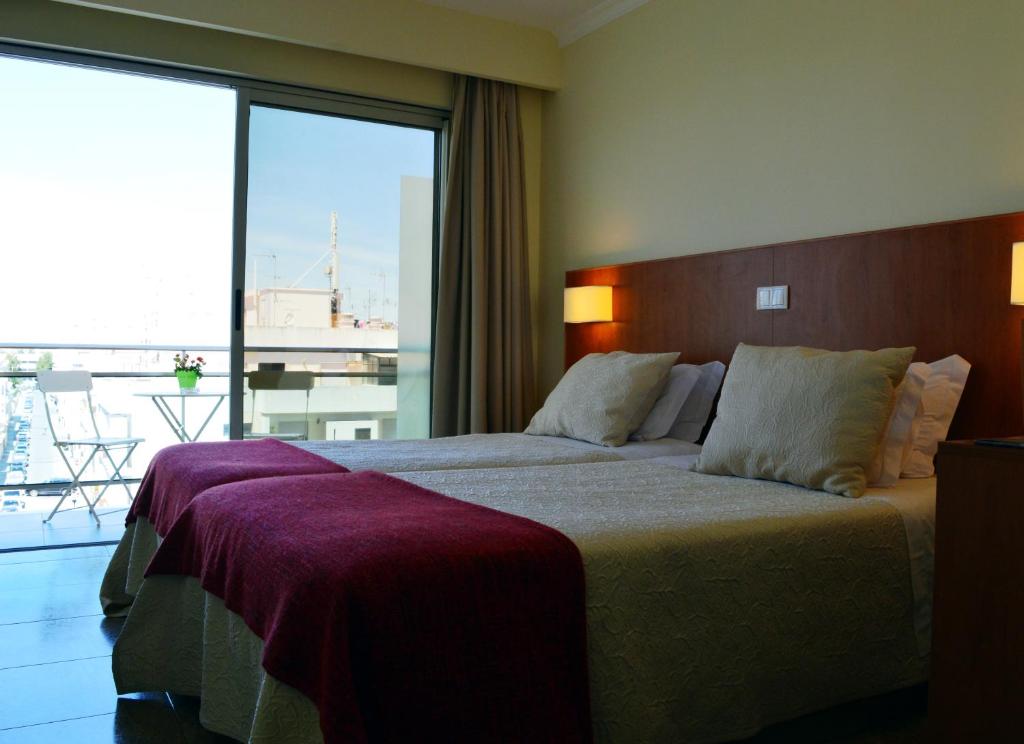 Twin room with balcony access and a small outdoor table and chairs.
