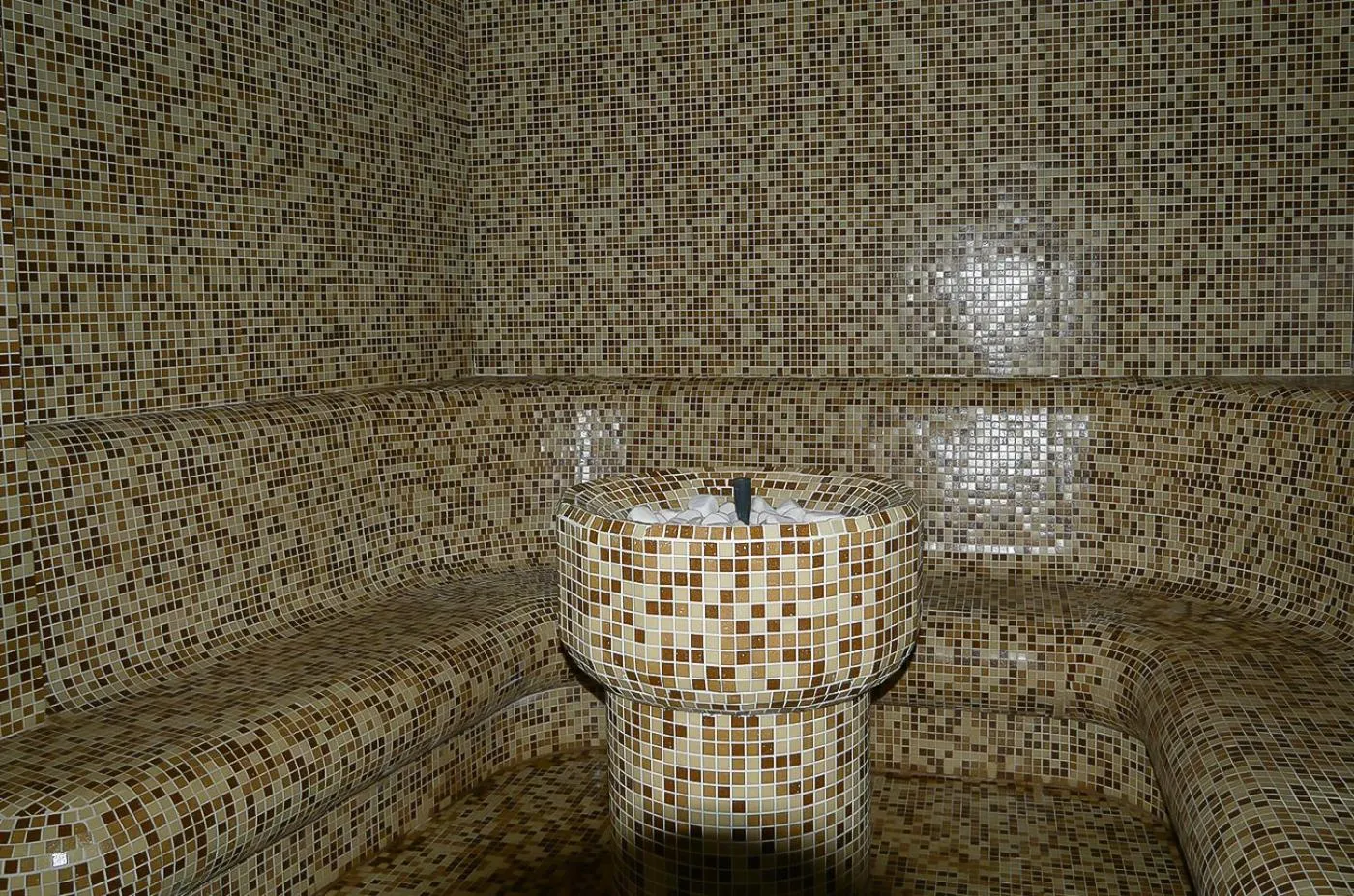 Tiled steam room with central stone fountain, used for athlete recovery during training camp