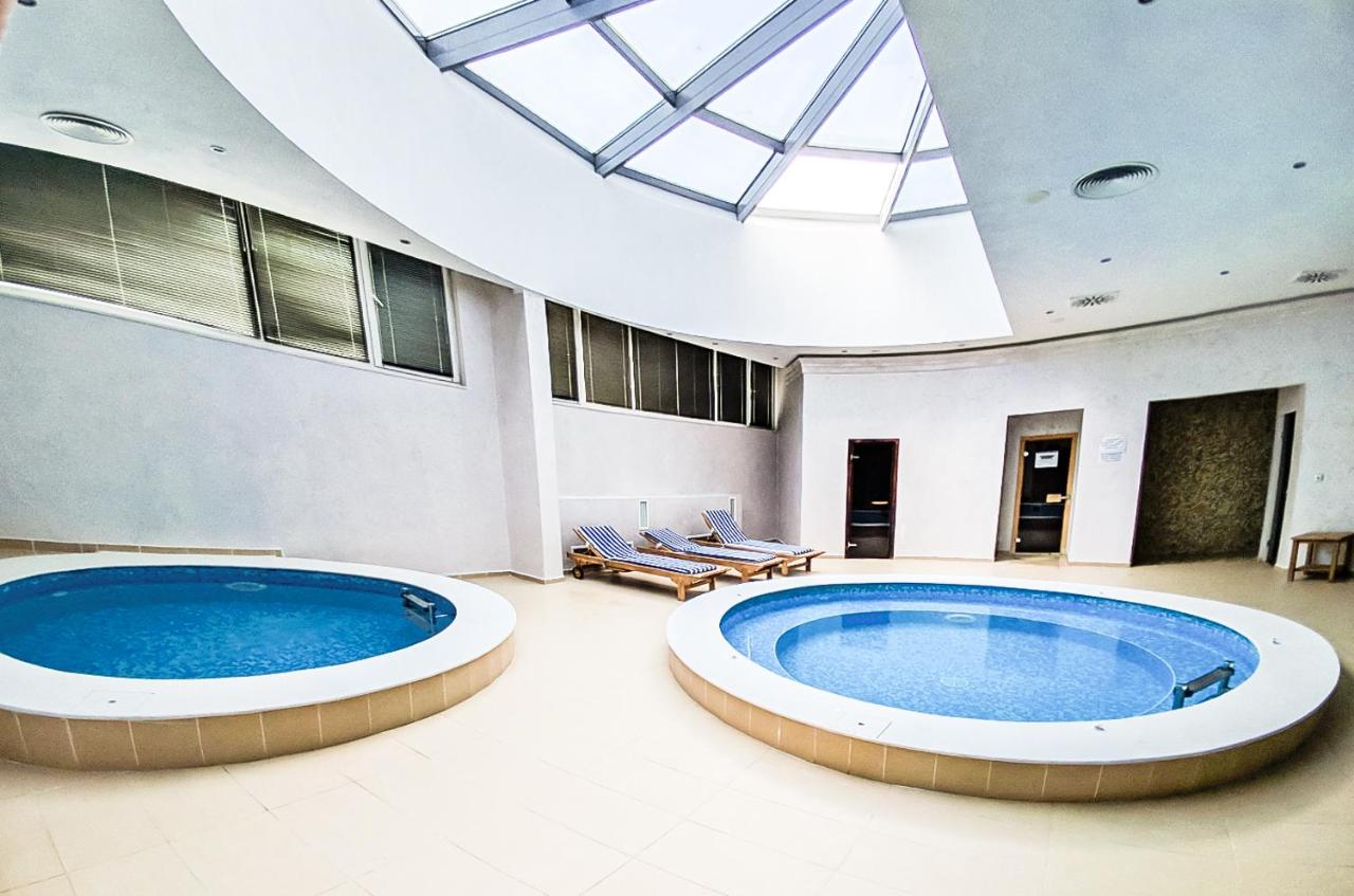 Indoor spa area with two round pools under skylight, recovery zone during training camp