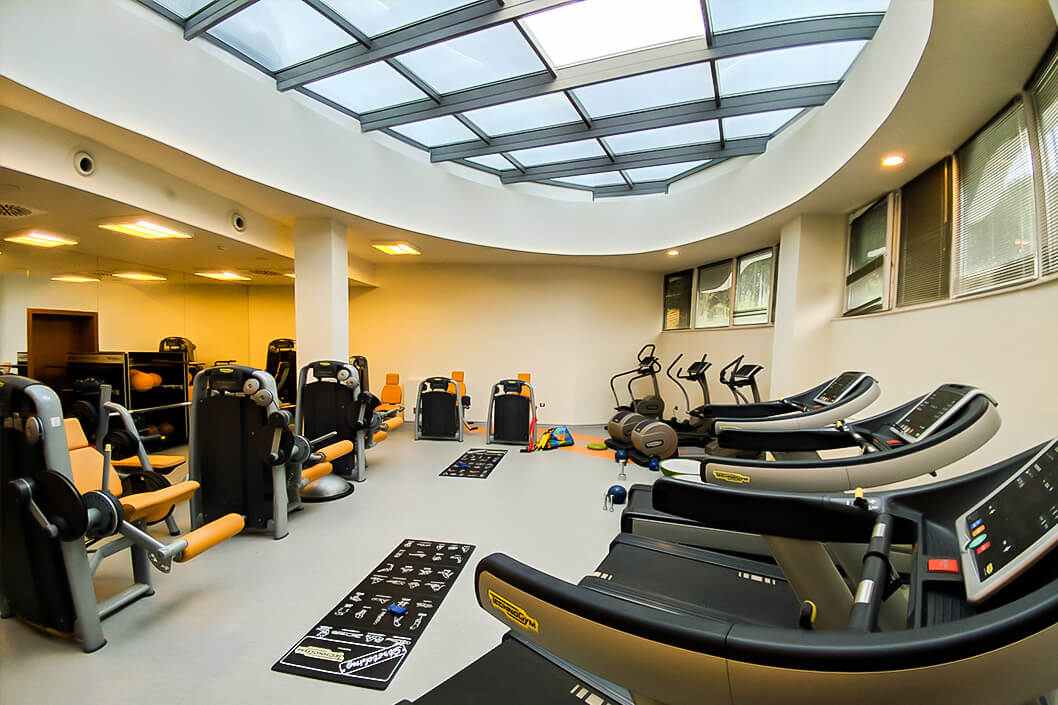 Hotel fitness center with treadmills, bikes, and strength machines for athlete workouts