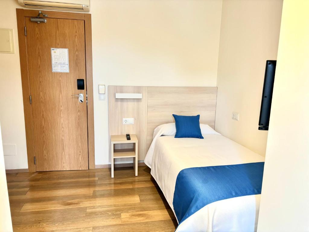 Compact single room with bed, bedside table, air-conditioning and flat-screen TV.