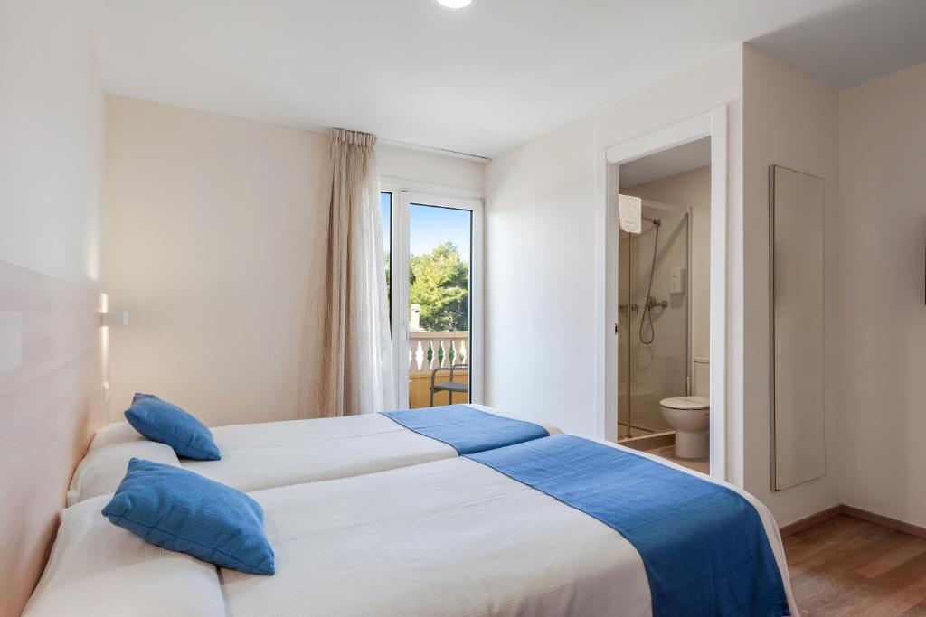 Twin room with two beds and open ensuite bathroom area with shower.
