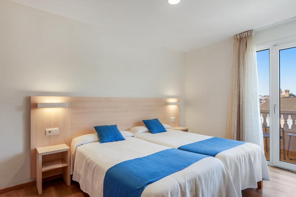 Twin room with balcony doors, two beds and visible shower room.