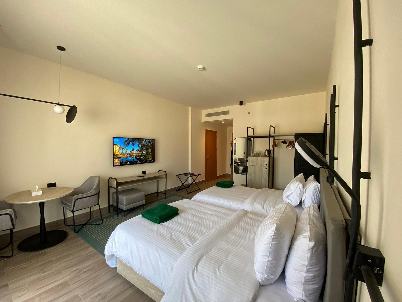 Spacious room with two single beds, seating area, and wall-mounted TV
