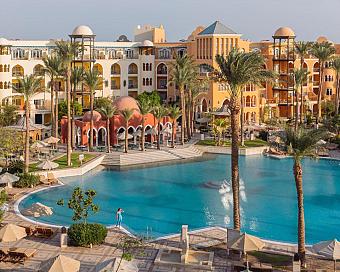Resort with large lagoon-style pool, palm trees, and colorful architecture