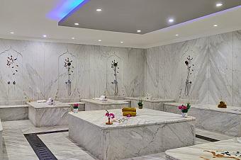 Luxurious marble spa room with massage tables and floral wall decorations