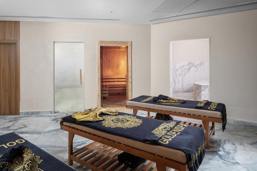Spa treatment room with two massage tables, towels, and sauna/steam area.