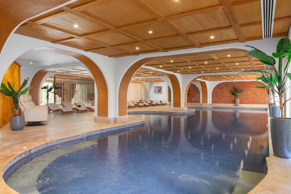 Indoor pool with loungers and arched seating areas for relaxation and recovery.