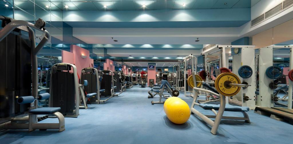 Fitness room with weight machines, bench press station, mirrors, and a stability ball for workout training.