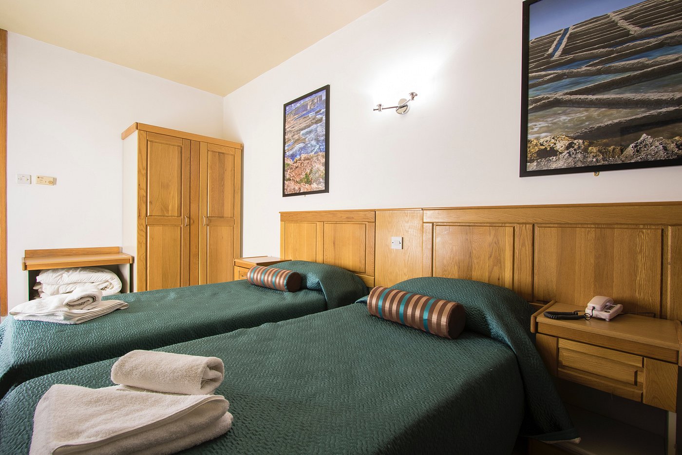 Twin room with two single beds, wardrobe, bedside table, and phone.