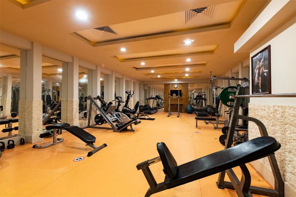 Fitness room with benches, machines and mirrored wall for strength training.