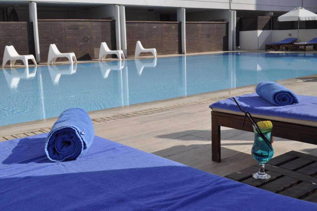 Outdoor pool with sun loungers, towels and a drink by the deck.