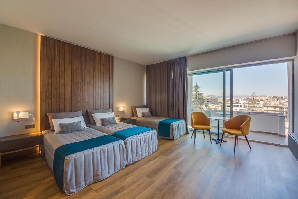 Guest room with twin beds, sofa bed and balcony seating.