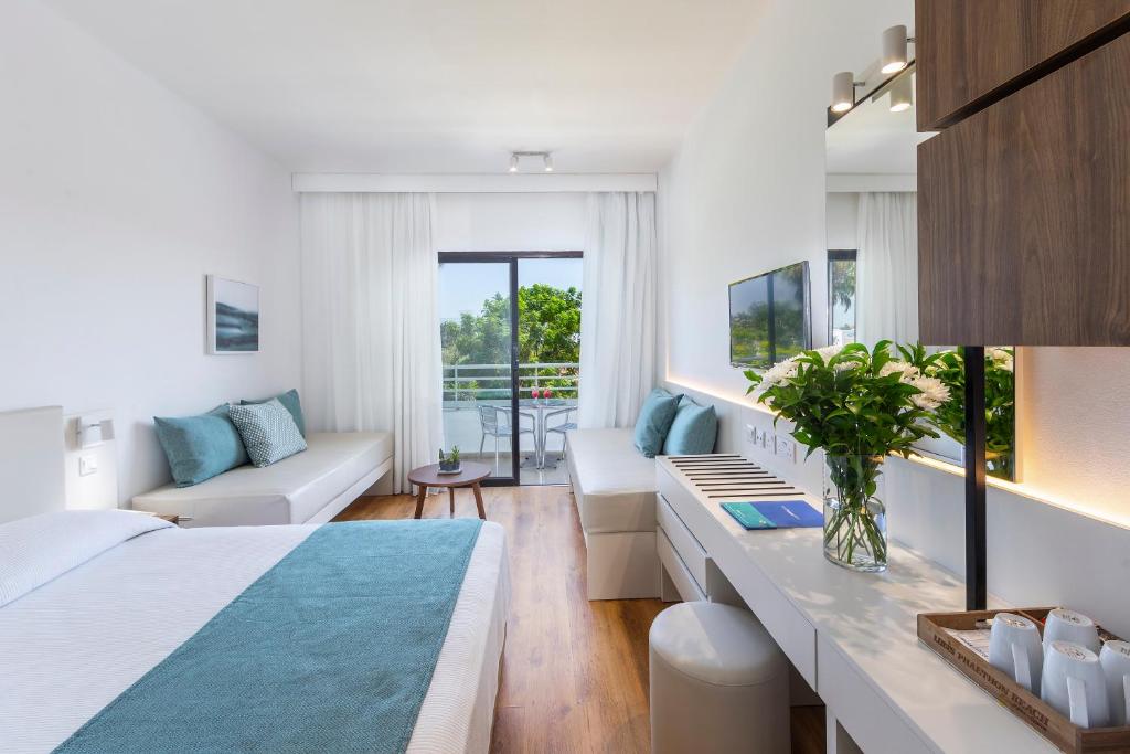 Bright guest room with desk, sofas and balcony view.