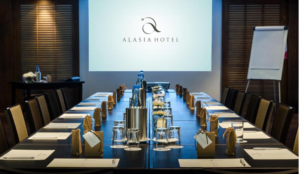 Conference room with long board table, projector screen and meeting setup.