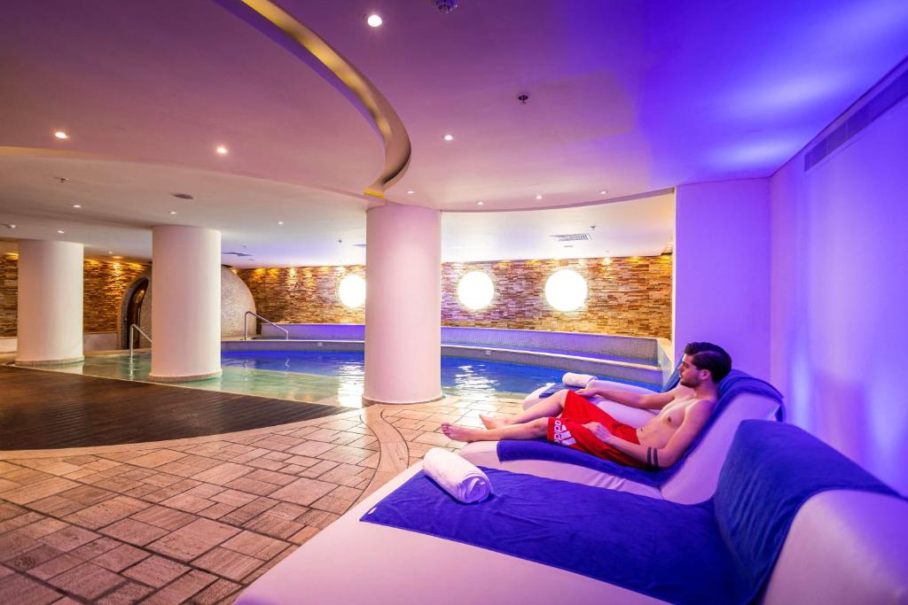 Innen-Spa-Pool mit Liegen und einem Gast im Erholungsbereich.