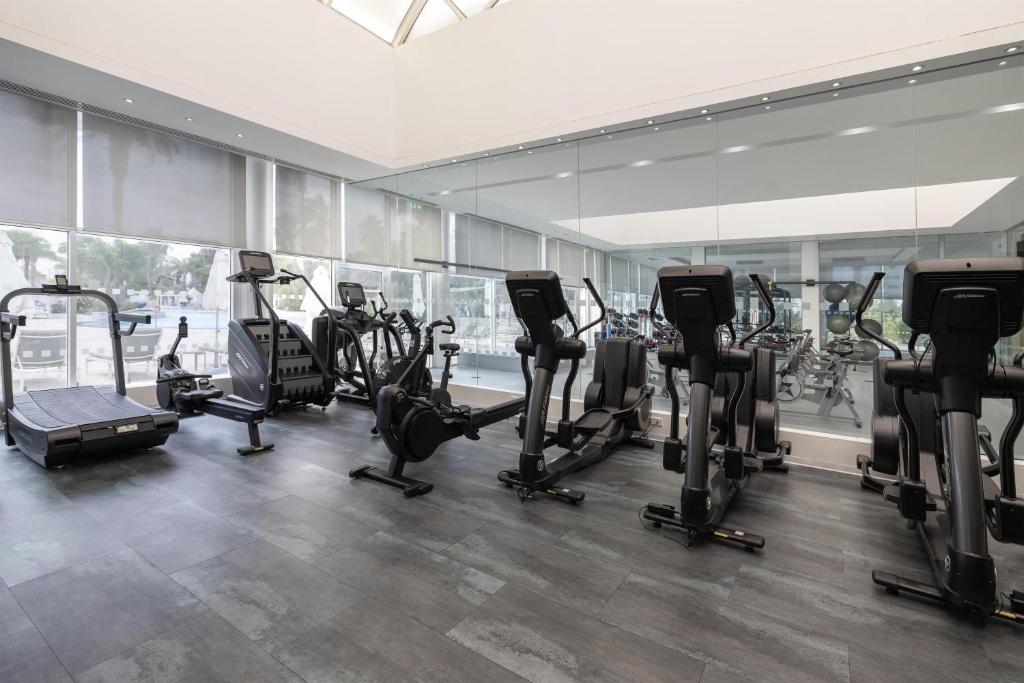 Fitnessraum mit Laufbändern, Fahrrädern, Crosstrainern und Spiegelwänden.