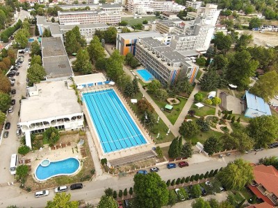 Luftaufnahme eines olympischen Außen-Schwimmbeckenkomplexes neben Hotelgebäuden, genutzt für Schwimmeinheiten im Trainingslager