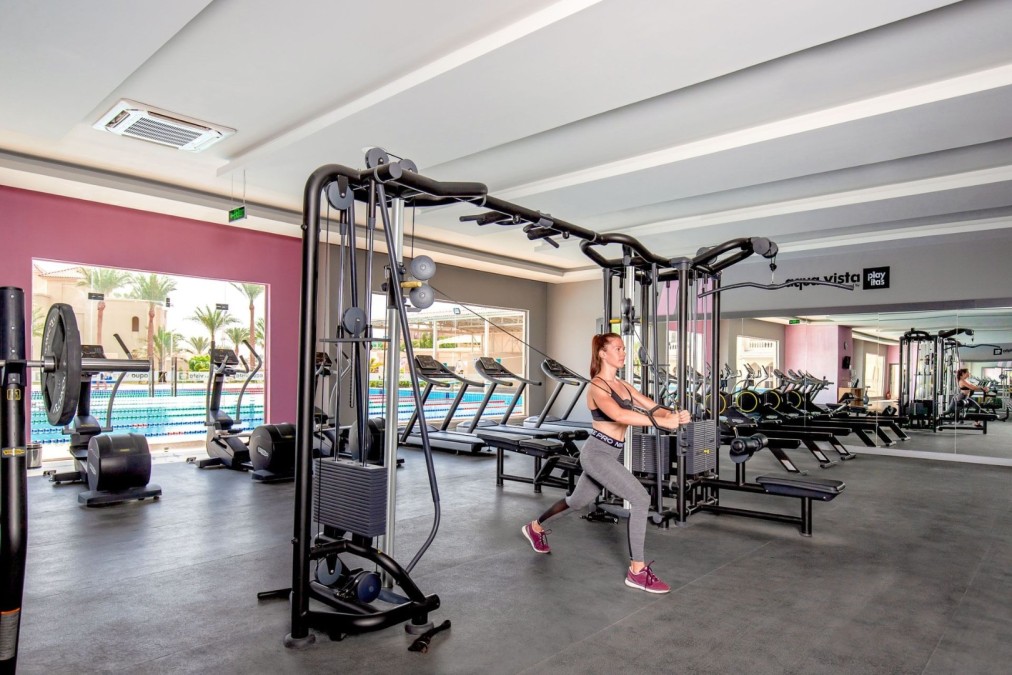 Athlet trainiert an einer Kraftmaschine in einem hellen, modernen Fitnessstudio