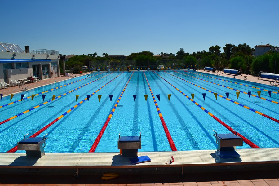 Draufsicht auf blaue Schwimmbecken neben dem Strand, ideal für Schwimmtrainingslager