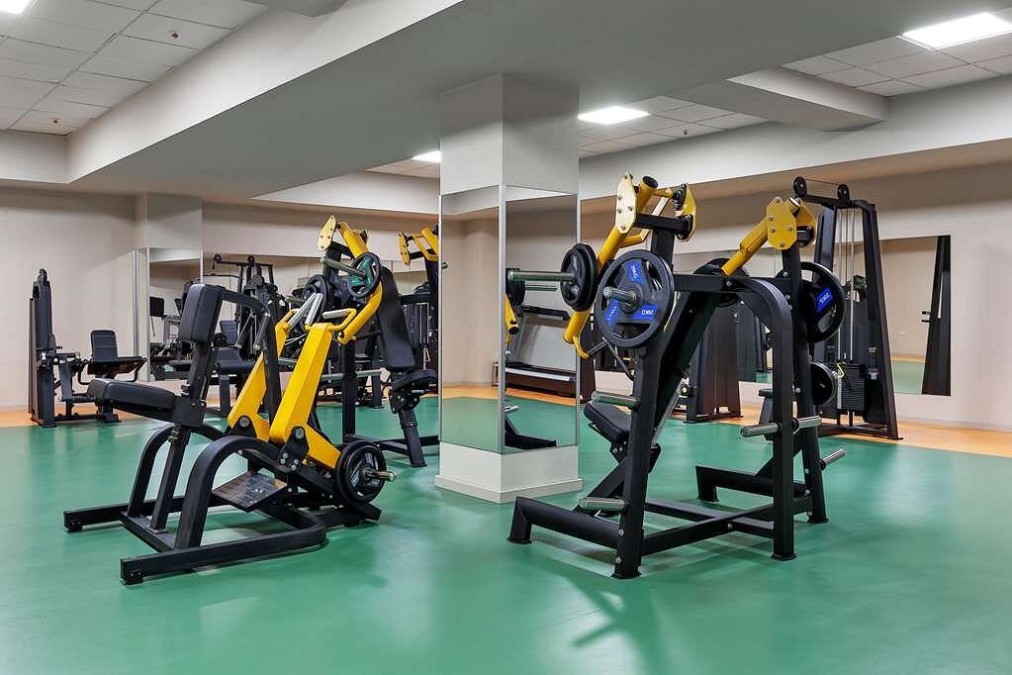 Fitnessraum mit Krafttrainingsmaschinen und grünem Bodenbelag für das Athletentraining