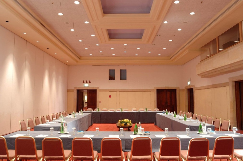 Geräumiger Konferenzraum mit U-förmiger Bestuhlung und Tischen, vorbereitet für Besprechungen im Trainingslager